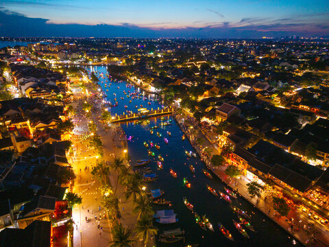 Panorama aerial drone view of Hoi An ancient town with boat tour and beautiful lanterns in sunset. UNESCO world heritage. One of the most travel popular touristic destinations
