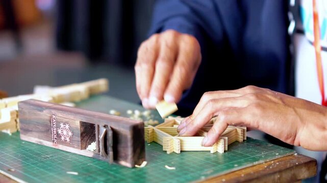 A woodworker is making a craft out of wood. Creating crafts using Japanese joinery techniques.