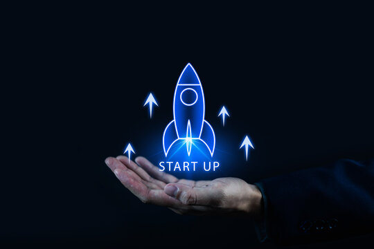 Startup launch concept with glowing rocket rising from an open hand, representing business growth, innovation, entrepreneurship, success, investment, leadership, digital transformation future vision.