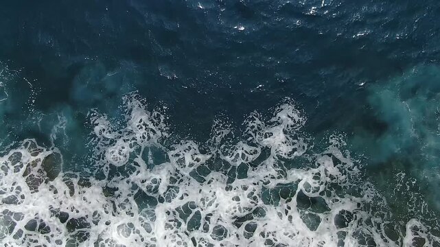 Aerial Top View of Powerful Ocean Waves Crashing into Deep Blue Sea Creating Natural Coastal Water Texture Background