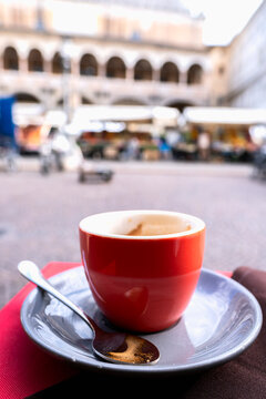 Close Up of an espresso coffee cup in Piazza della Frutta in Padua, Italy, with the historic Palazzo della Ragione in the background