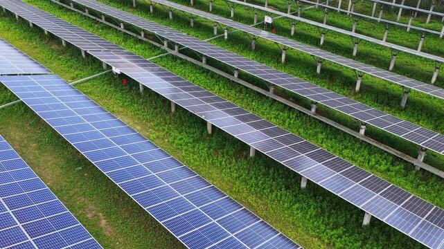 Drone view of photovoltaic solar panels in green rural field