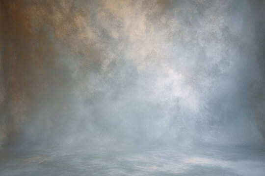 Light blue studio painted backdrop. Muted golden tones. Canvas background on the wall and on the floor with a soft transition.