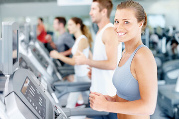 Fototapeta premium Fitness, portrait and happy woman on treadmill in gym for workout, lose weight or cardio exercise. Active, female person or runner with smile on machine for weightloss or wellness in health club