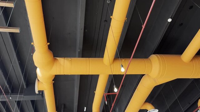Modern industrial ceiling design with yellow HVAC ventilation ducts