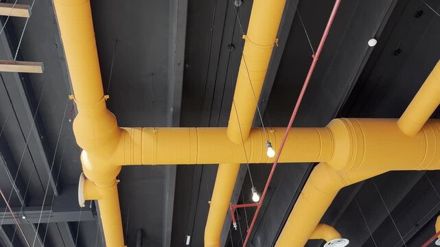 Modern industrial ceiling design with yellow HVAC ventilation ducts