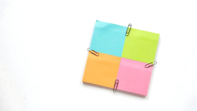 Colorful sticky notes with paper clips on white background  office supplies and stationery