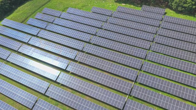 Wide aerial view of photovoltaic arrays in green landscape