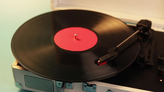 Vintage turntable playing a vinyl record with a red label