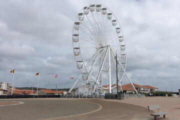 White Ferris wheel by seaside promenade under cloudy sky. Biscarrosse Plage, Atlantic © HighDispersion