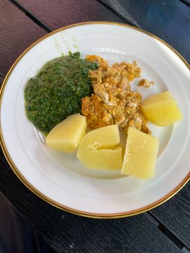 Kartoffeln mit R&uuml;hrei und Rahmspinat auf dem Teller. Leichtes Sommergericht, traditionelle deutsche K&uuml;che, schnelles Mittagessen, ausgewogene Ern&auml;hrung und hausgemachter Genuss.