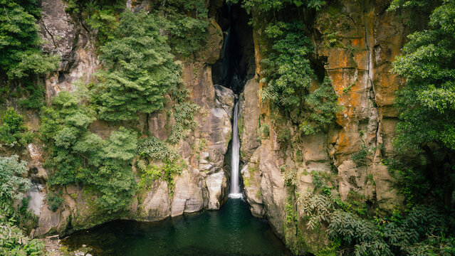 Salto do cabrito waterfall is flowing into a lush green natural pool surrounded by rock walls