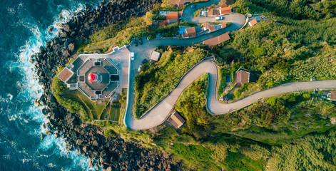 Arnel lighthouse standing on sao miguel coastline at dusk © Alberto