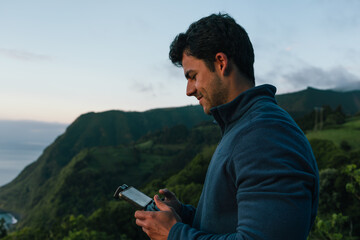 Young man flying drone over sao miguel landscape at dusk © Alberto