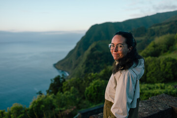 Woman standing on cliff admiring sao miguel coastline at dusk © Alberto