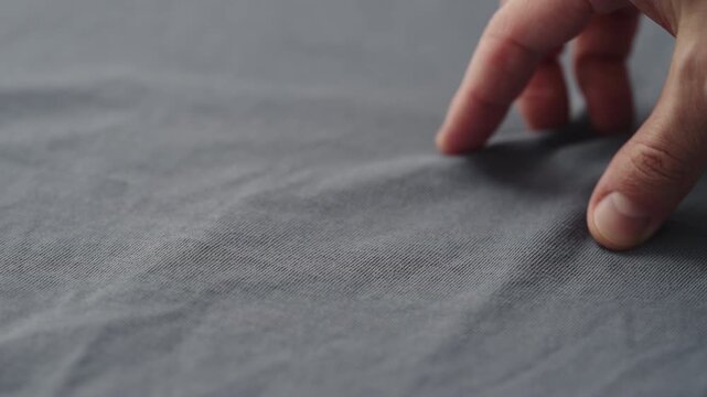 man manually check ivory color cotton fabric for clothing with hands