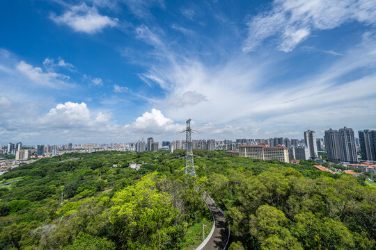 High-voltage transmission towers on a mountain overlooking the city.