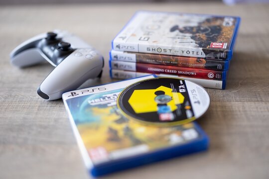 BRECHT, BELGIUM &ndash; July 10, 2026: Macro photo of a closed PS5 game case with a stack of PlayStation 5 games in the background, highlighting physical gaming media.