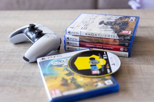 BRECHT, BELGIUM &ndash; July 10, 2026: PlayStation 5 controller and physical PS5 game collection displayed together, representing console gaming and entertainment.