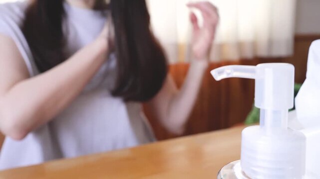 ヘアオイルを髪につける女性
