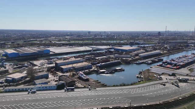 Drone approach over road toward industrial scrapyard