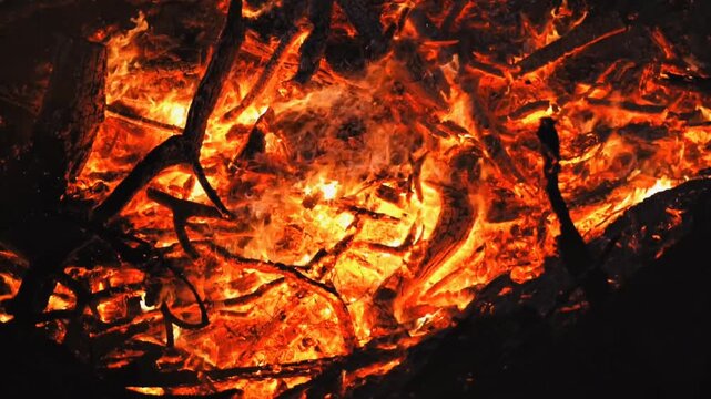 Dramatic top-down view of intense glowing red and orange embers inside a large wood fire. Excellent for high-heat industrial concepts, abstract elemental textures, or cozy hearth videos.