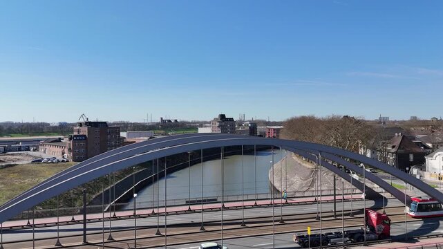 Rising drone beside rail bridge over canal and passing train