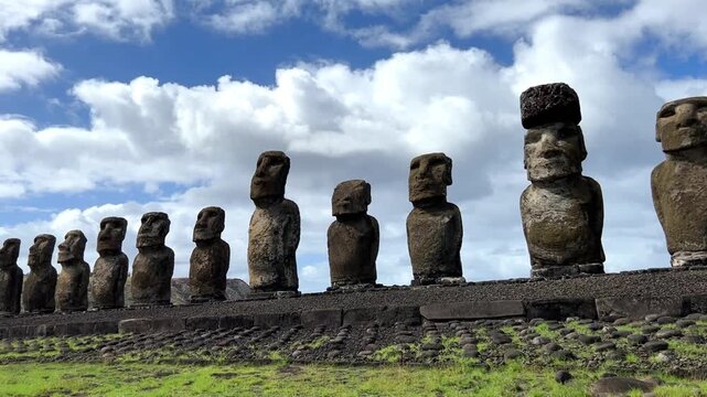 Daytime view of Ahu Tongariki on Easter Island, Chile. Fifteen iconic Moai statues standing against a bright blue sky and the Pacific Ocean. Famous archaeological site and UNESCO World Heritage 