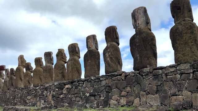 Daytime view of Ahu Tongariki on Easter Island, Chile. Fifteen iconic Moai statues standing against a bright blue sky and the Pacific Ocean. Famous archaeological site and UNESCO World Heritage 