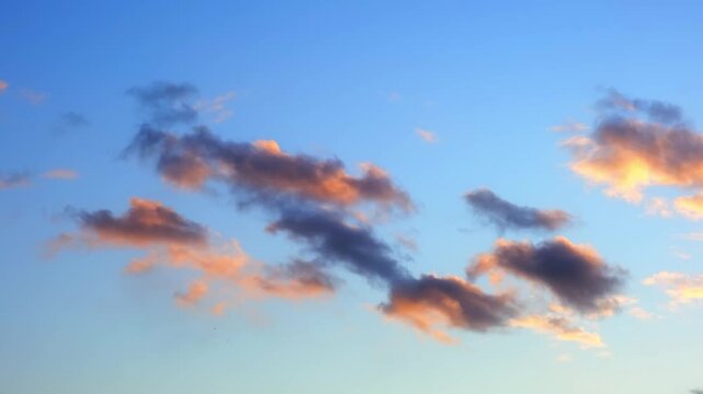 Morning or evening sky. Colorful clouds fill twilight with gradients of purple, pink and orange during sunset or sunrise. Natural background. Beauty in nature. Expressive cloudscape. High quality 4K.