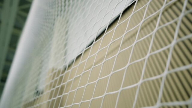 Stretched protective netting provides reliable spectator defense in training center. Functional details outline structure of sports facility