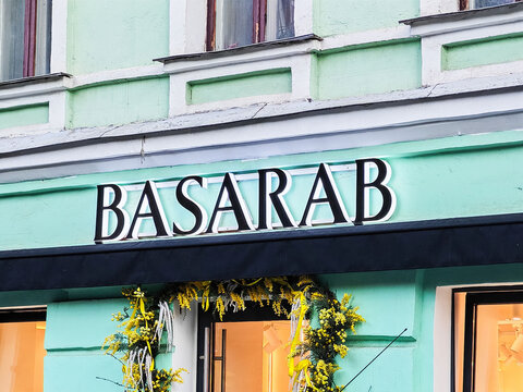 Moscow, Russia - June 21, 2026: Basarab storefront with decorative floral arrangement and green facade, featuring large lettering on a black awning in an urban setting