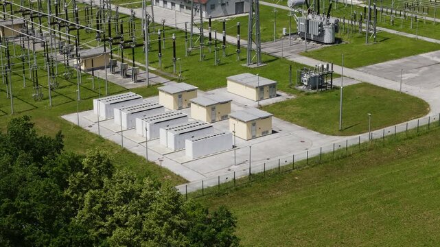Aerial view of battery energy storage system - BESS beside a substation for managing renewable energy, smart grid and grid stabilization.