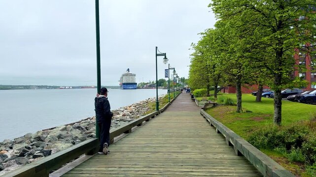 A man walking along Sydney, NS Canada harbor
