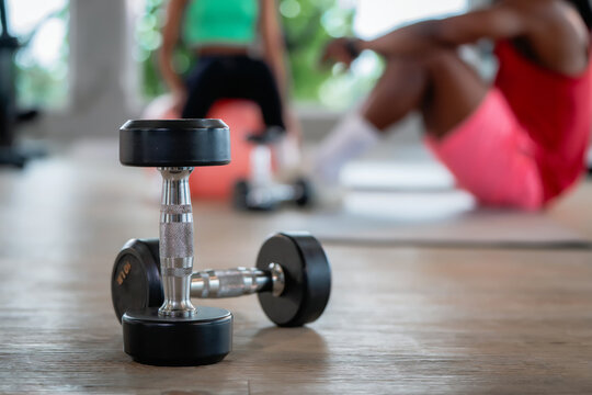 Close up weights dumbbells blur family fitness workout break. Scene for family fitness, healthy active lifestyle, free weights workout and weight training.