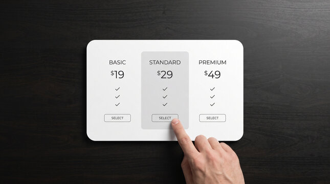 Human hand choosing the standard pricing plan on a digital interface screen with wooden background