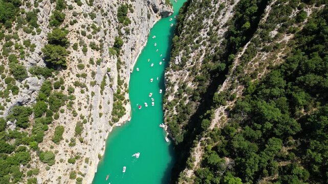 Aerial view of the turquoise waters of Verdon Gorge surrounded by dramatic limestone cliffs in Provence, France on a sunny summer day