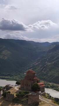Jvari monastery in mtskheta georgia overlooking the aragvi and mtkvari rivers with a dramatic cloudy sky and a panoramic view of the caucasus mountains landscape