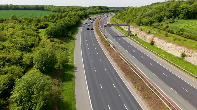 Aerial drone footage above a busy UK motorway following and tracking traffic with dynamic motion in countryside