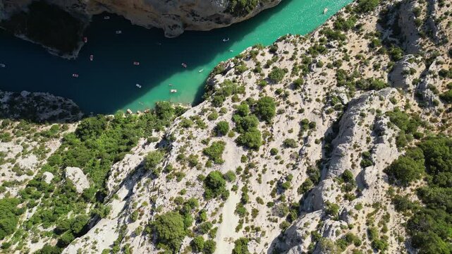 Aerial view of the turquoise waters of Verdon Gorge surrounded by dramatic limestone cliffs in Provence, France on a sunny summer day
