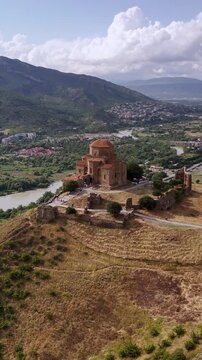 Scenic aerial view of the ancient jvari monastery on a hilltop overlooking the confluence of the mtkvari and aragvi rivers near mtskheta, georgia on a sunny day