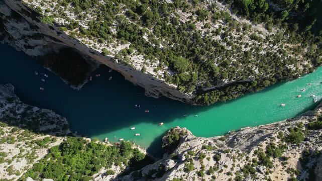 Aerial view of the turquoise waters of Verdon Gorge surrounded by dramatic limestone cliffs in Provence, France on a sunny summer day