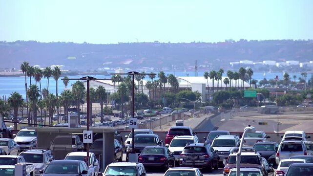 Traffic on a busy road in San Diego with palm trees and ocean in the background in 4k