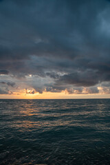 Naklejka premium Sunset over the sea after rain with thunder clouds. Sky background.