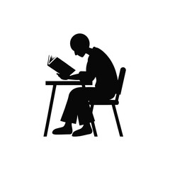 Fototapeta premium Student silhouette sitting at a desk while reading a book in a quiet and focused environment.