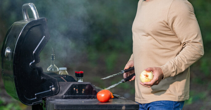 Man roast meat with vegetable in barbecue at backyard. Grilling and BBQ. Chef cook vegetable grill outdoor. Restaurant menu. Man chef hold grilled vegetable. Healthy food. Marinated vegetables