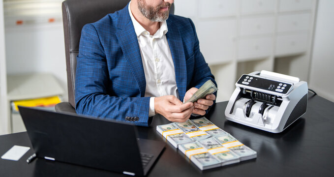 Money counter. Money counting machine. Economic wealth and value investing. Electronic money counter machine counting dollar banknote. Finance and business. Man cropped view