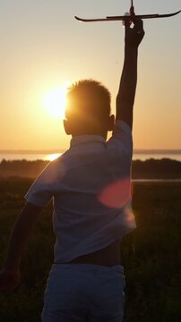 Silhouette of a happy child running with a toy airplane through a field during a warm, golden sunset, embodying the spirit of freedom, imagination, and a carefree childhood summer