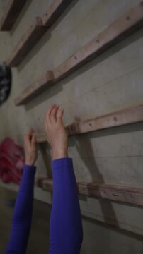 Vertical screen Close up of hands training grip strength on a campus board building finger endurance for climbing performance and harder outdoor routes