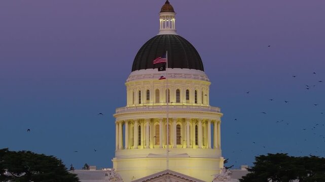 Aerial views showcase the west side of California State Capitol at night with lights shining and the new annex being built
